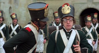 Movie still from “Love and Death” (1975), directed by Woody Allen – A group of men in uniforms are standing together; Medium shot, Over the shoulder angle