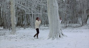Movie still from “Love and Death” (1975), directed by Woody Allen – Two people in the snow next to a large tree; Wide shot, Low angle