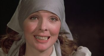 Movie still from “Love and Death” (1975), directed by Woody Allen – A person wearing a headscarf and smiling; Close Up shot, Low angle