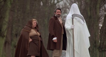 Movie still from “Love and Death” (1975), directed by Woody Allen – A man and a woman dressed as a ghost and a man with a scythe; Wide shot, Low angle
