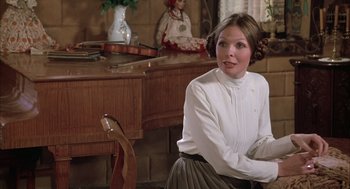 Movie still from “Love and Death” (1975), directed by Woody Allen – A woman sitting on a chair in front of a desk; Medium shot, Over the shoulder angle