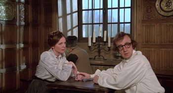 Movie still from “Love and Death” (1975), directed by Woody Allen – A man and a woman sitting at a table in front of candles; Medium shot, Over the shoulder angle