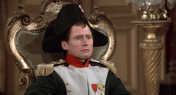 Movie still from “Love and Death” (1975), directed by Woody Allen – A man in a military uniform sitting in a chair; Close Up shot, High angle