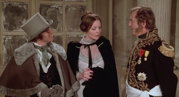 Movie still from “Love and Death” (1975), directed by Woody Allen – A woman in a black and white dress standing next to two other people; Medium shot, Over the shoulder angle