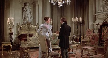 Movie still from “Love and Death” (1975), directed by Woody Allen – A woman in a white dress talking to a man in a black coat; Wide shot, Over the shoulder angle