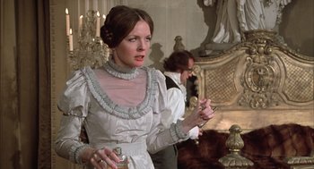 Movie still from “Love and Death” (1975), directed by Woody Allen – A woman in a white dress holding a bottle of perfume; Medium shot, Over the shoulder angle