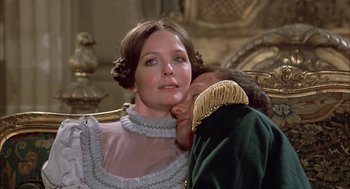 Movie still from “Love and Death” (1975), directed by Woody Allen – A man and a woman are kissing on the cheek; Medium shot, Low angle