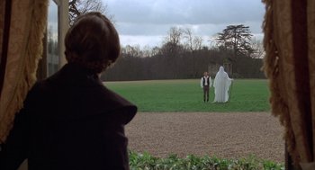 Movie still from “Love and Death” (1975), directed by Woody Allen – A man and a woman standing in the grass; Wide shot, Over the shoulder angle