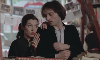 Movie still from “Love on the Run” (1979), directed by François Truffaut – A man and a woman sitting at a table together; Medium shot, Low angle