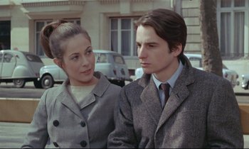 Movie still from “Love on the Run” (1979), directed by François Truffaut – A man and a woman standing next to each other on the street; Medium shot, Over the shoulder angle