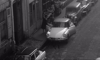 Movie still from “Love on the Run” (1979), directed by François Truffaut – An old photo of a car parked on the side of the street; Wide shot, High angle