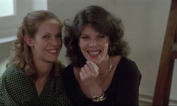 Movie still from “Love on the Run” (1979), directed by François Truffaut – Two women smile for the camera while posing for a picture; Close Up shot, Low angle