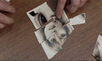Movie still from “Love on the Run” (1979), directed by François Truffaut – A hand is holding a piece of torn paper with a picture of a woman's face on it; Extreme Close Up shot, Overhead angle