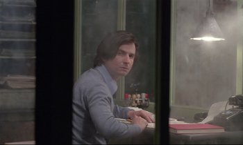 Movie still from “Love on the Run” (1979), directed by François Truffaut – A man sitting at a table in front of a window; Medium shot, Over the shoulder angle