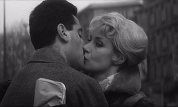 Movie still from “Love on the Run” (1979), directed by François Truffaut – A man and a woman kissing each other in the street; Close Up shot, Low angle