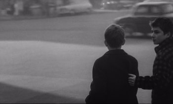 Movie still from “Love on the Run” (1979), directed by François Truffaut – A young boy standing on the side of a road; Medium shot, High angle