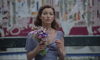 Movie still from “Love on the Run” (1979), directed by François Truffaut – A beautiful woman holding a bouquet of flowers in her hands; Medium shot, Low angle