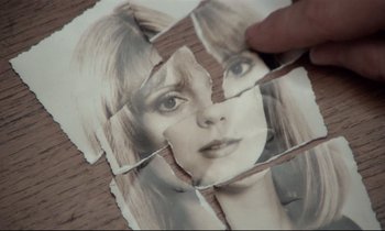 Movie still from “Love on the Run” (1979), directed by François Truffaut – A hand holding a piece of paper with a picture of a woman's face on it; Extreme Close Up shot, Overhead angle