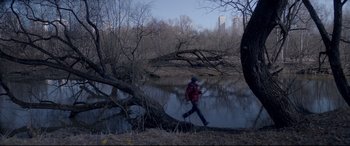Movie still from “Loveless” (2017), directed by Andrey Zvyagintsev – A man is running through the woods near a river; Extreme Wide shot, High angle