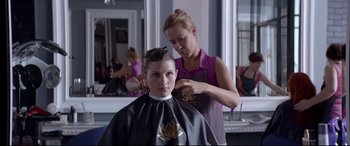 Movie still from “Loveless” (2017), directed by Andrey Zvyagintsev – A young girl getting her hair cut by a stylist; Medium shot, Over the shoulder angle