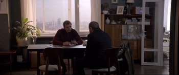 Movie still from “Loveless” (2017), directed by Andrey Zvyagintsev – Two men sitting at a table talking to each other; Medium shot, Over the shoulder angle