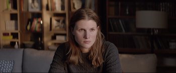 Movie still from “Loveless” (2017), directed by Andrey Zvyagintsev – A woman with long brown hair sitting in a room; Close Up shot, Over the shoulder angle
