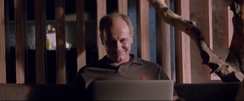 Movie still from “Loveless” (2017), directed by Andrey Zvyagintsev – A man sitting in front of an open laptop computer; Close Up shot, Low angle