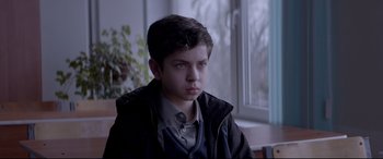 Movie still from “Loveless” (2017), directed by Andrey Zvyagintsev – A young boy is sitting in front of a window; Medium shot, High angle