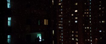 Movie still from “Loveless” (2017), directed by Andrey Zvyagintsev – A man sitting at a table in front of an open window at night; Extreme Wide shot, Low angle