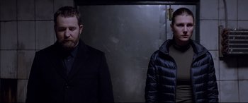 Movie still from “Loveless” (2017), directed by Andrey Zvyagintsev – Two men standing next to each other wearing jackets; Medium shot, Low angle