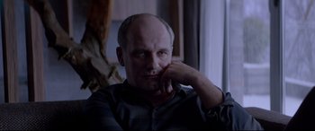 Movie still from “Loveless” (2017), directed by Andrey Zvyagintsev – A man with a bald head sitting in front of a window; Close Up shot, Over the shoulder angle