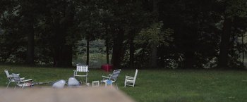 Movie still from “Lovesong” (2016), directed by So Yong Kim – A group of lawn chairs sitting in the middle of a field; Extreme Wide shot, High angle