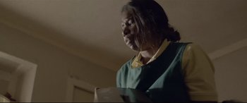 A woman standing in a living room holding a book