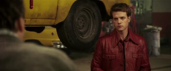 Movie still from “Lucky Number Slevin” (2006), directed by Paul McGuigan – A man in a red jacket standing in front of a yellow truck; Close Up shot, Over the shoulder angle