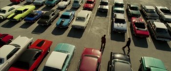 Movie still from “Lucky Number Slevin” (2006), directed by Paul McGuigan – A man standing in the middle of a parking lot; Extreme Wide shot, Overhead angle