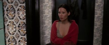Movie still from “Lucky Number Slevin” (2006), directed by Paul McGuigan – A woman wearing a red sweater is sitting in a chair; Medium shot, High angle