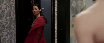 Movie still from “Lucky Number Slevin” (2006), directed by Paul McGuigan – A woman in a red dress walking down a street; Medium shot, Over the shoulder angle
