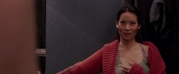 Movie still from “Lucky Number Slevin” (2006), directed by Paul McGuigan – A woman in a red sweater posing for a picture; Close Up shot, Over the shoulder angle