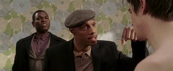 Movie still from “Lucky Number Slevin” (2006), directed by Paul McGuigan – A man wearing a hat and a suit; Close Up shot, Over the shoulder angle