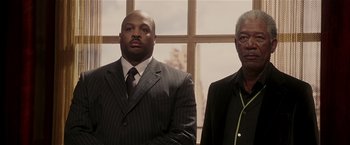 Movie still from “Lucky Number Slevin” (2006), directed by Paul McGuigan – Two men standing next to each other in front of a window; Medium shot, Low angle