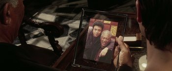 Movie still from “Lucky Number Slevin” (2006), directed by Paul McGuigan – A person holding up a picture of a man and a woman; Extreme Close Up shot, Overhead angle