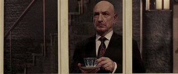 Movie still from “Lucky Number Slevin” (2006), directed by Paul McGuigan – A man in a suit holding a cup of tea; Close Up shot, Low angle