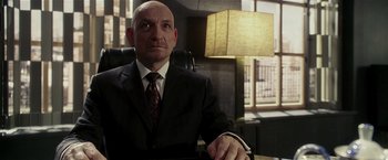 Movie still from “Lucky Number Slevin” (2006), directed by Paul McGuigan – A man in a suit and tie sitting at a desk; Close Up shot, Low angle