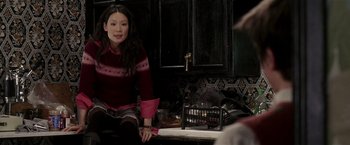 Movie still from “Lucky Number Slevin” (2006), directed by Paul McGuigan – A woman sitting on a counter in front of a sink; Medium shot, Over the shoulder angle