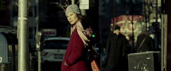 Movie still from “Lucky Number Slevin” (2006), directed by Paul McGuigan – A woman in a red coat is walking down the street; Medium shot, Over the shoulder angle