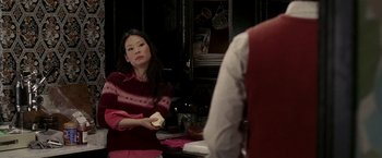Movie still from “Lucky Number Slevin” (2006), directed by Paul McGuigan – A woman sitting at a table with a sandwich in front of her face; Medium shot, Over the shoulder angle