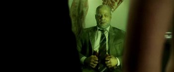 Movie still from “Lucky Number Slevin” (2006), directed by Paul McGuigan – A man in a suit and tie sitting in front of a mirror; Medium shot, High angle