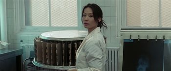 Movie still from “Lucky Number Slevin” (2006), directed by Paul McGuigan – A woman standing in a room next to a radiator; Medium shot, Low angle