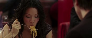 Movie still from “Lucky Number Slevin” (2006), directed by Paul McGuigan – A woman is eating some food while sitting at a table; Close Up shot, Overhead angle