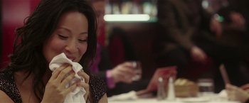 Movie still from “Lucky Number Slevin” (2006), directed by Paul McGuigan – A woman sitting at a table with a napkin in her mouth; Close Up shot, Over the shoulder angle